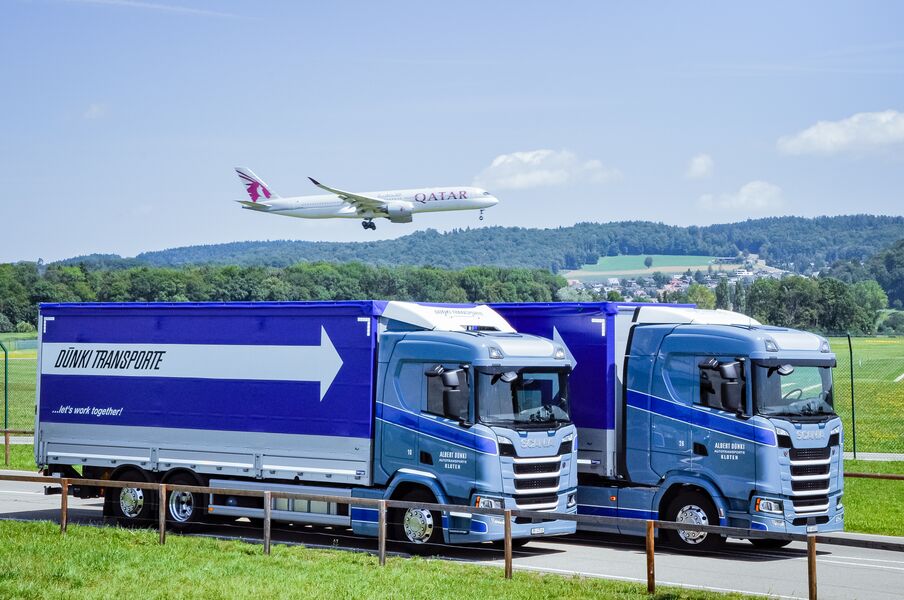 Dünki LKW's mit Flugzeug im Hintergrund - Dünki Transporte AG - Kloten, Schweiz