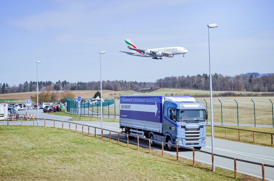 Dünki LKW's mit Flugzeug im Hintergrund - Dünki Transporte AG - Kloten, Schweiz